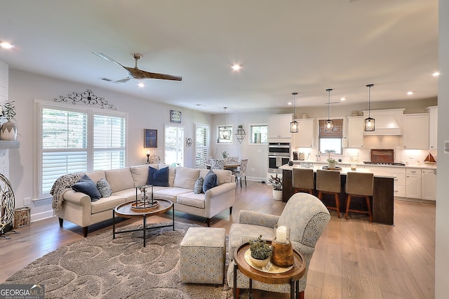 living room with light wood-type flooring and ceiling fan