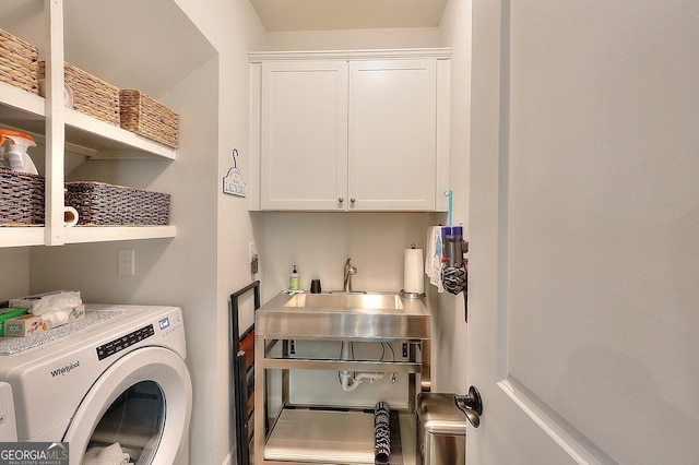 laundry room featuring cabinets, independent washer and dryer, and sink