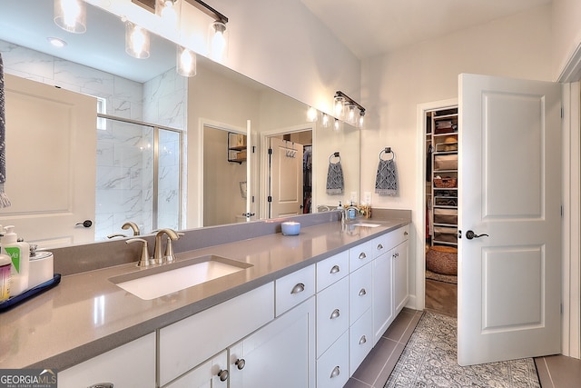 bathroom featuring vanity, a shower with shower door, and tile patterned flooring