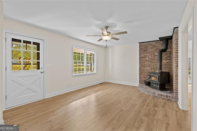 unfurnished living room with ceiling fan, a wealth of natural light, and light wood-type flooring