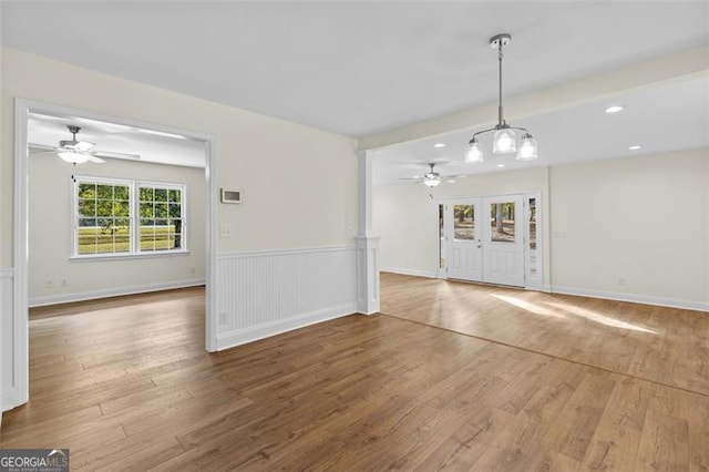 unfurnished living room with french doors, ceiling fan, and hardwood / wood-style floors