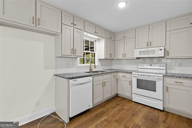 kitchen featuring decorative backsplash, white cabinets, hardwood / wood-style flooring, and white appliances