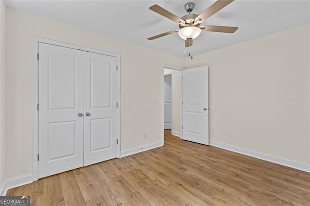 unfurnished bedroom featuring light hardwood / wood-style flooring, a closet, and ceiling fan