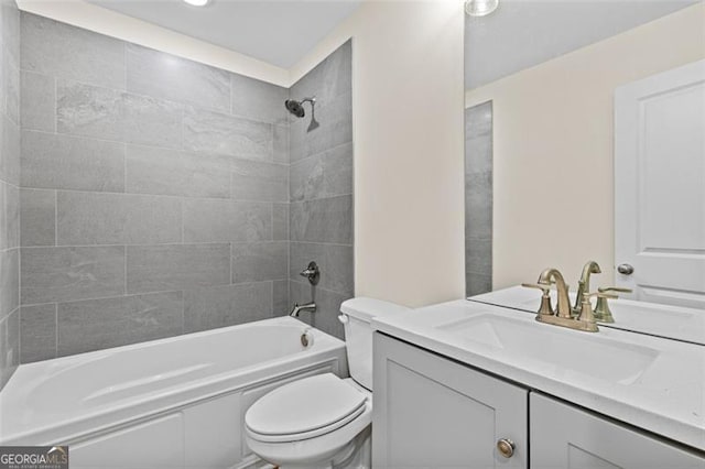 full bathroom with tiled shower / bath, vanity, and toilet