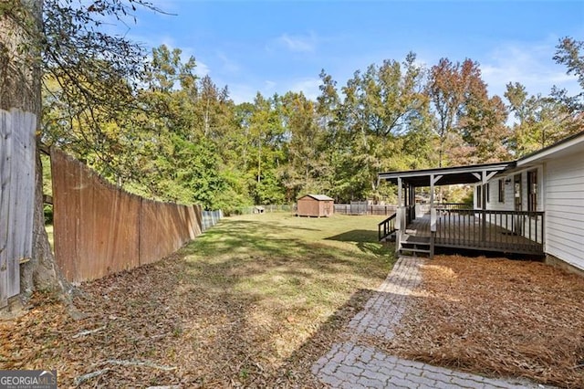 view of yard featuring a wooden deck and a shed