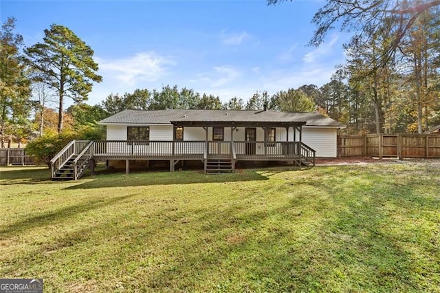 rear view of property with a deck and a lawn