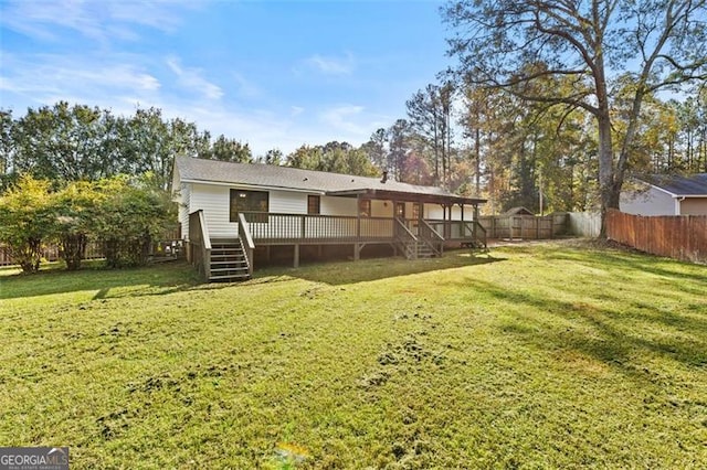 back of property featuring a wooden deck and a lawn