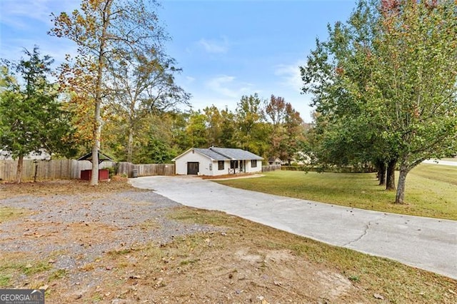 single story home featuring a front lawn and a storage shed