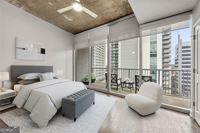 bedroom with wood-type flooring, access to outside, and ceiling fan