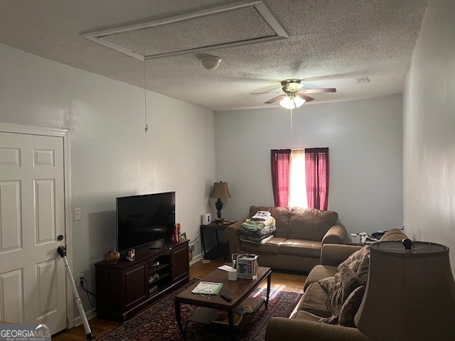 living room with ceiling fan, a textured ceiling, and dark hardwood / wood-style flooring