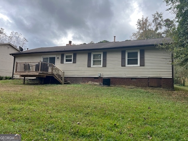 rear view of house featuring central air condition unit, a yard, and a deck