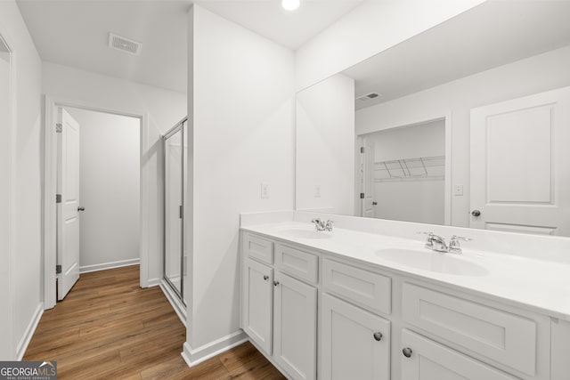 bathroom with vanity, wood-type flooring, and an enclosed shower