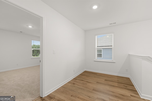 empty room with light hardwood / wood-style flooring and plenty of natural light