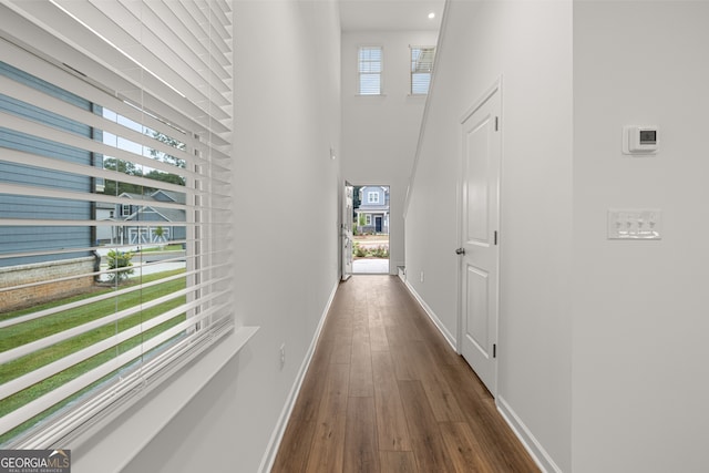 corridor with a healthy amount of sunlight and dark hardwood / wood-style flooring