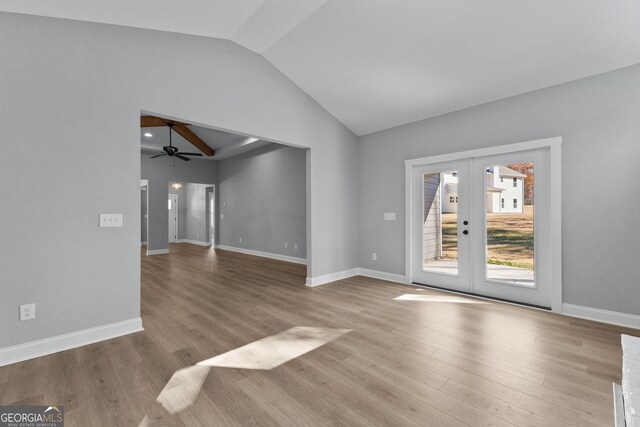 empty room featuring ceiling fan, vaulted ceiling, light hardwood / wood-style flooring, and french doors