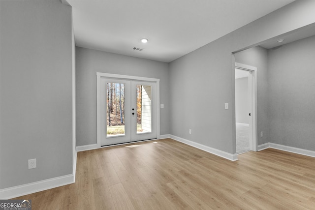 unfurnished room featuring french doors and light hardwood / wood-style flooring