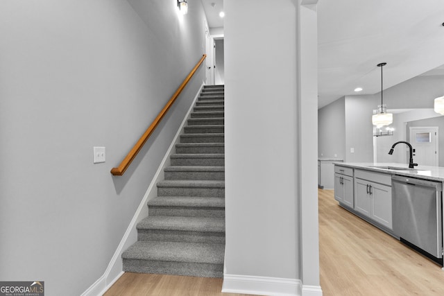 staircase featuring sink and wood-type flooring