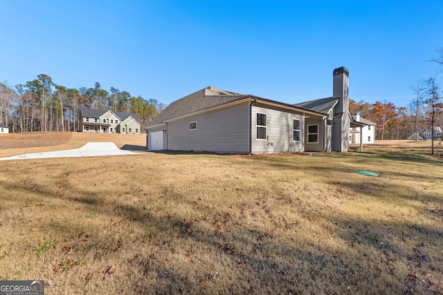 view of property exterior with a garage and a yard