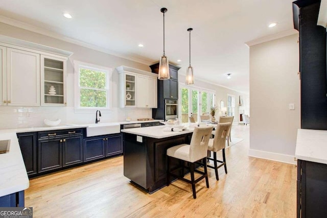 kitchen with white cabinetry, decorative light fixtures, light hardwood / wood-style floors, and plenty of natural light