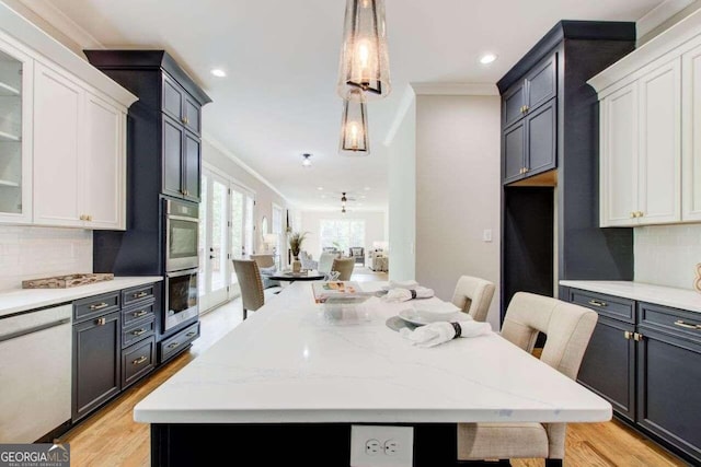 kitchen with ornamental molding, decorative backsplash, and white cabinetry