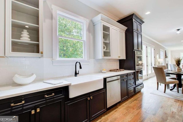 kitchen featuring sink, white cabinetry, stainless steel appliances, and backsplash