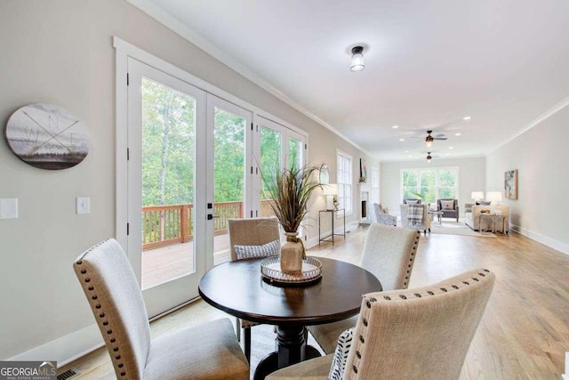 dining room featuring light hardwood / wood-style flooring, ceiling fan, and crown molding