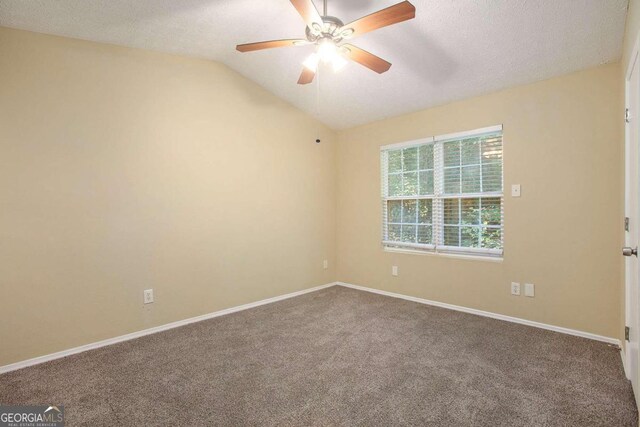 carpeted empty room with vaulted ceiling, a textured ceiling, and ceiling fan