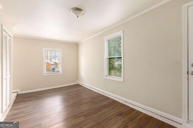 unfurnished bedroom featuring crown molding and dark hardwood / wood-style flooring