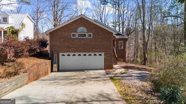 view of front of house with brick siding, an attached garage, and driveway