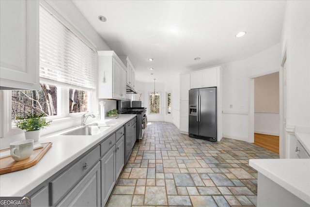 kitchen with a sink, appliances with stainless steel finishes, gray cabinets, and light countertops