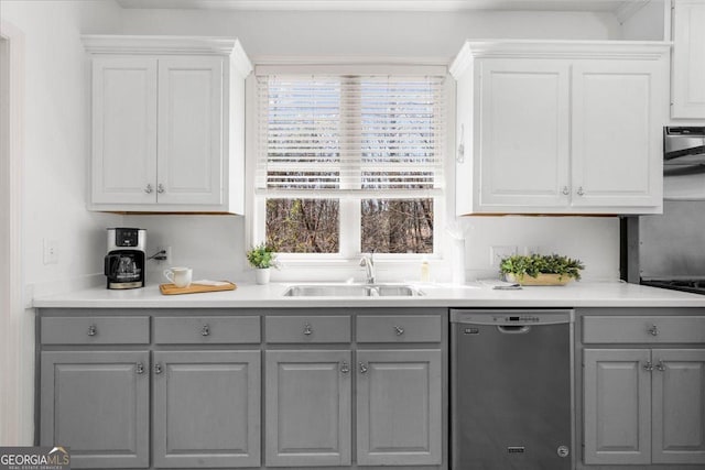 kitchen featuring white cabinets, dishwasher, a sink, and gray cabinetry