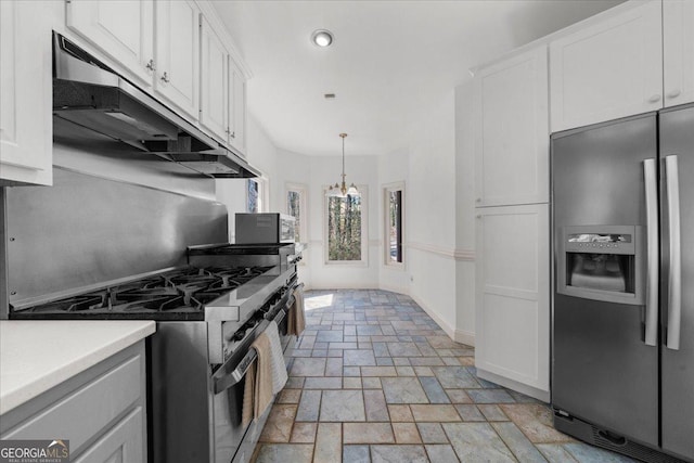 kitchen featuring white cabinetry, stone finish floor, ventilation hood, and stainless steel appliances