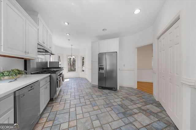 kitchen featuring stone finish flooring, under cabinet range hood, light countertops, stainless steel appliances, and white cabinetry