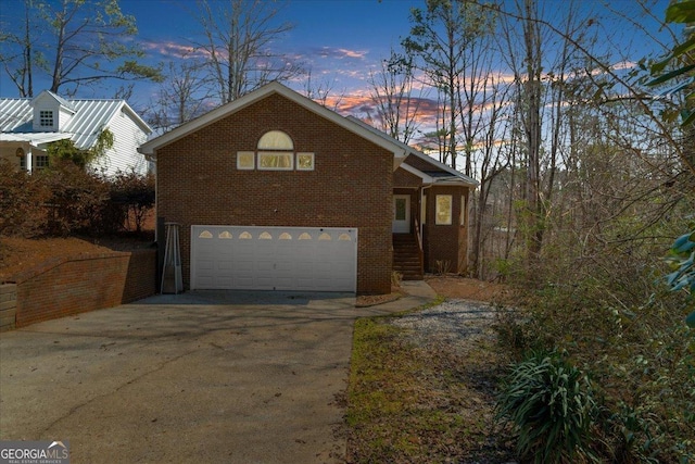 view of front of property with brick siding, driveway, and a garage