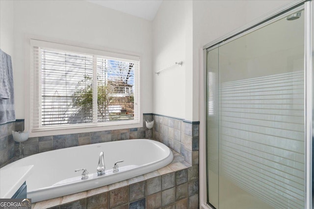 bathroom featuring a garden tub and a shower stall
