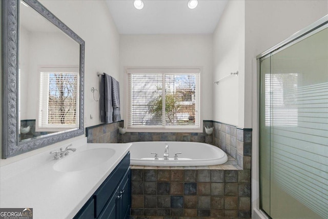 bathroom with a garden tub, vanity, an enclosed shower, and recessed lighting