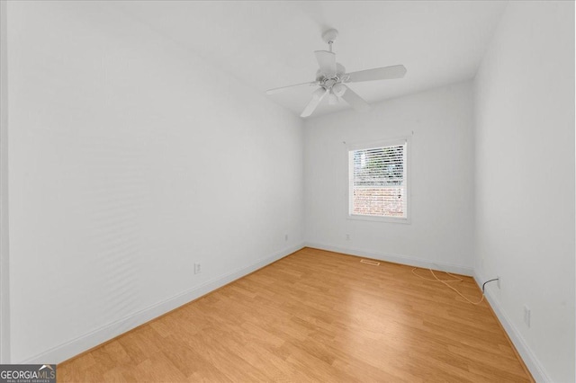 unfurnished room with light wood-style flooring, a ceiling fan, and baseboards