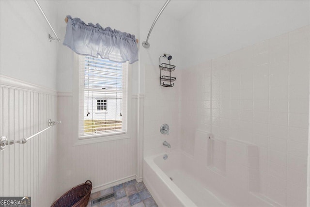 bathroom with shower / bathing tub combination, visible vents, and baseboards