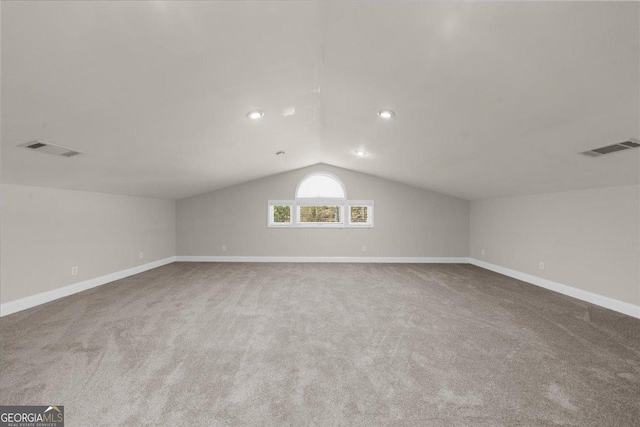 additional living space featuring lofted ceiling, visible vents, and carpet flooring