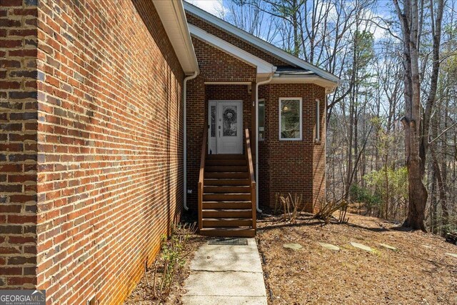 doorway to property featuring brick siding