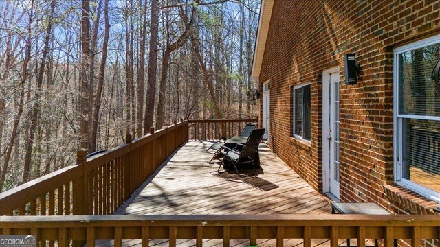 wooden terrace featuring a forest view