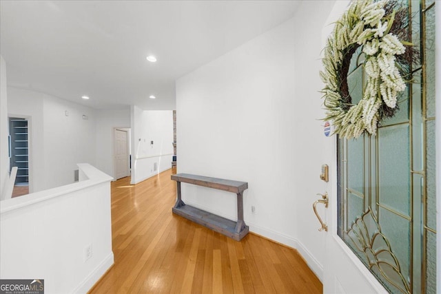 hallway with recessed lighting, baseboards, an upstairs landing, and light wood finished floors