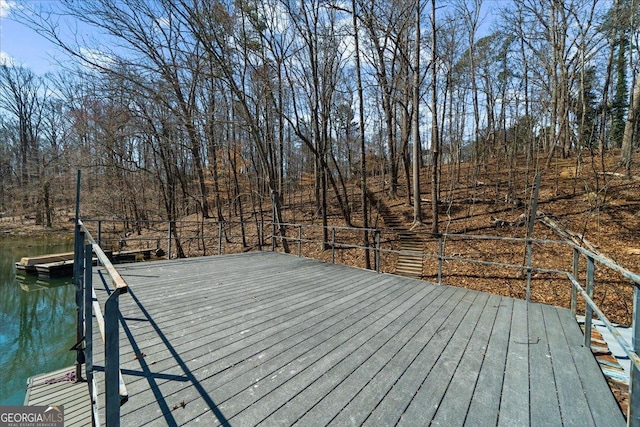 wooden deck featuring a floating dock and a water view