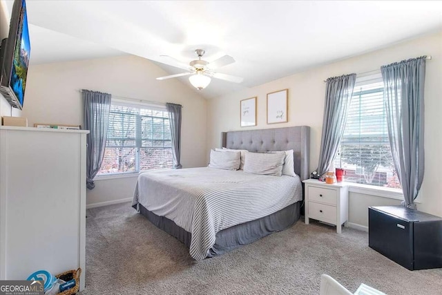 bedroom with multiple windows, vaulted ceiling, light colored carpet, and ceiling fan