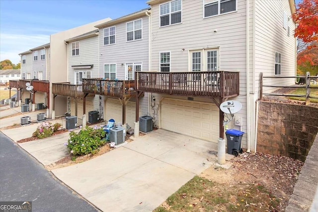 rear view of house featuring central AC unit and a garage