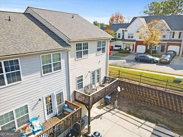 back of house with a garage and central air condition unit