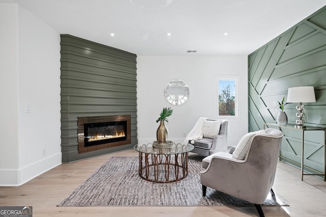 sitting room with a fireplace and light hardwood / wood-style floors