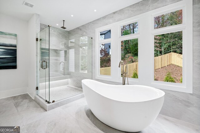 bathroom featuring independent shower and bath