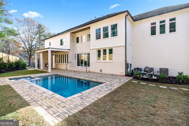 back of property featuring a yard, a fenced in pool, and a patio