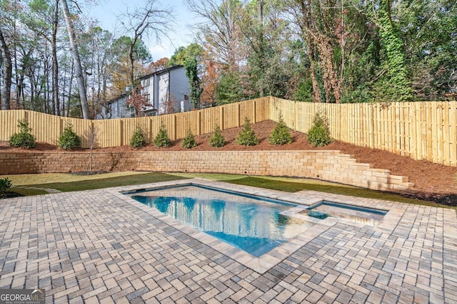 view of pool with a patio area and an in ground hot tub